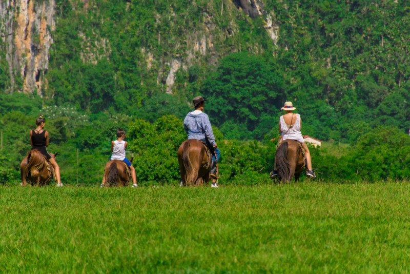 Persoane călărind cai în Valea Viñales